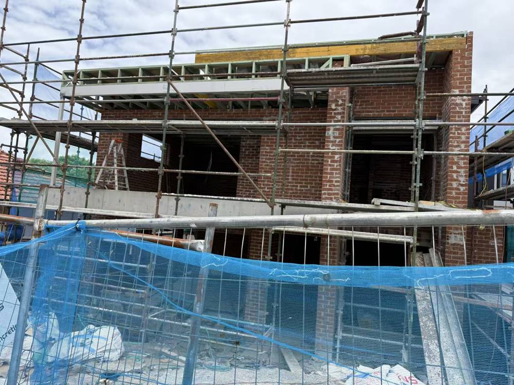 Brick walls and steel framing behind scaffolding