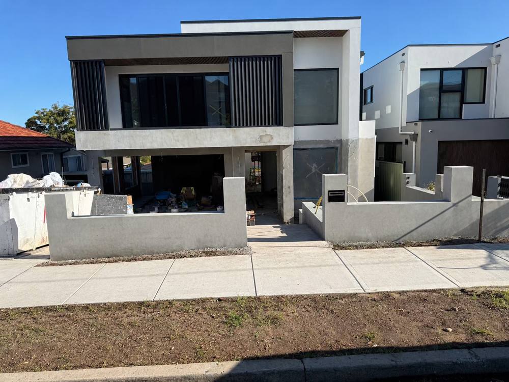 Front of a two-storey home with rendered fence and slatted screens